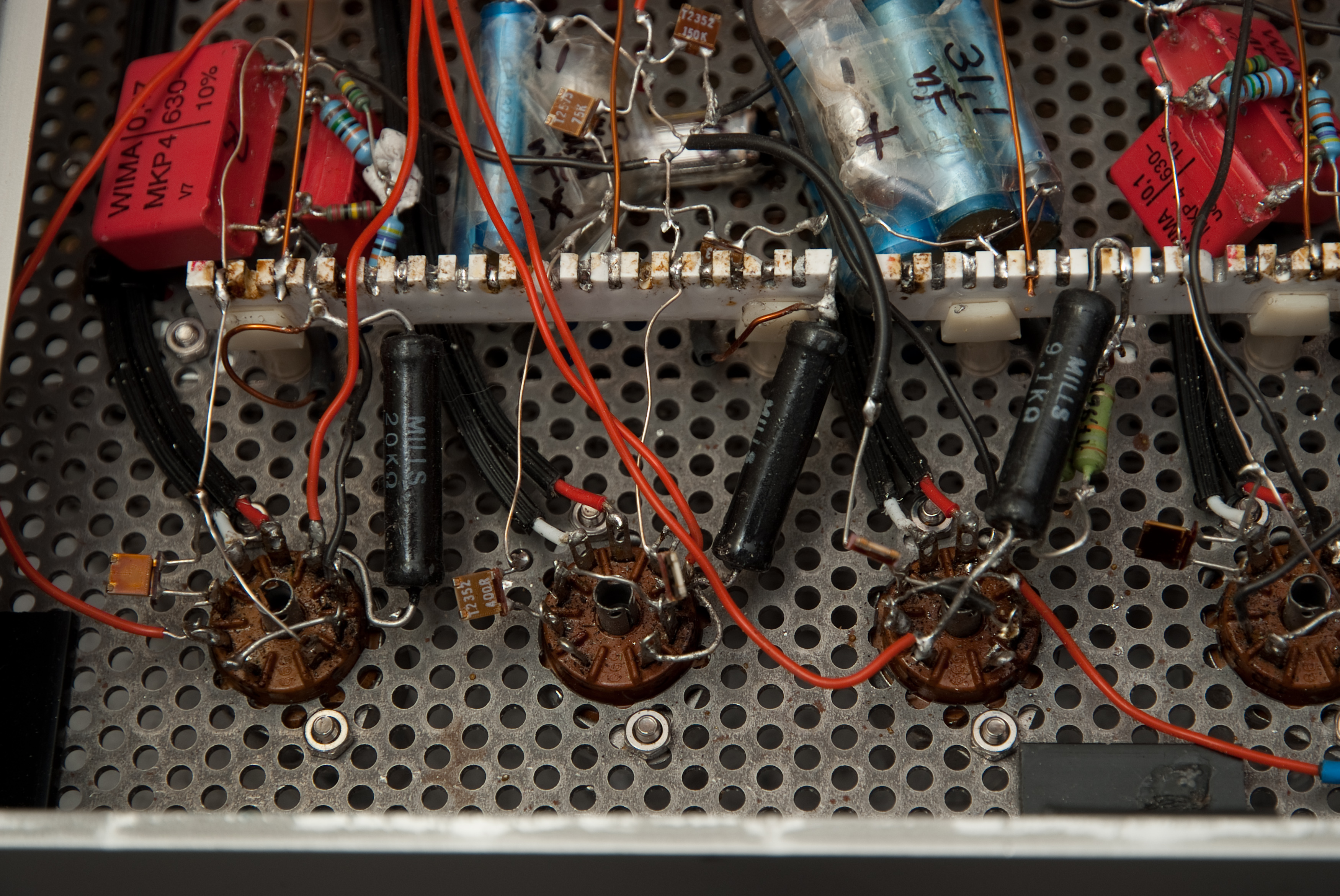 Figure 9 — Recapping in progress on a point-to-point tube chassis. With the original paper caps replaced by modern film (and the electrolytics attended to at the same time), an amplifier or radio c…