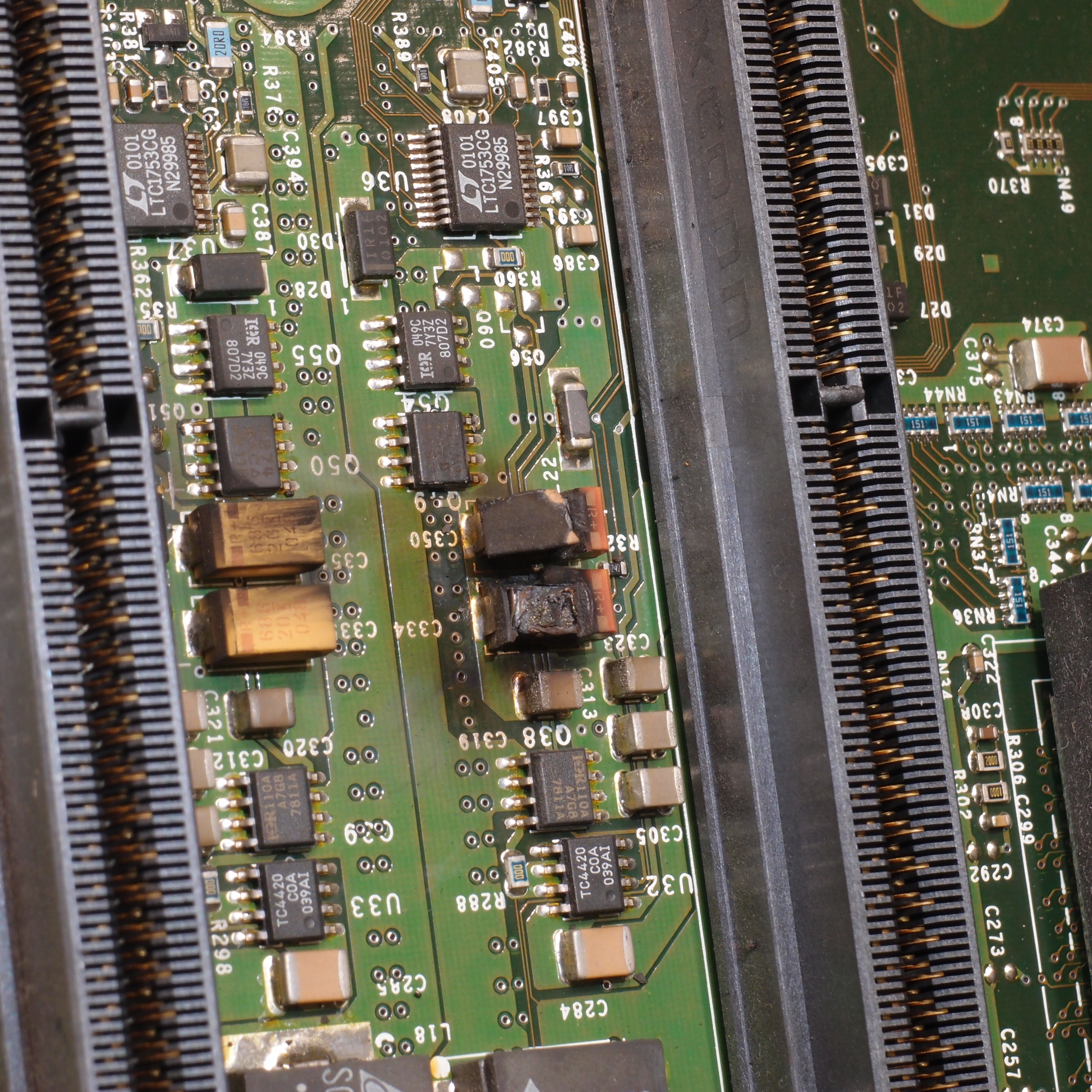 Figure 9 — A tantalum capacitor destroyed by its ignition failure mode: charred body and scorched board, the reason for aggressive voltage derating. Source: htomari, Wikimedia Commons, CC BY-SA 2.0.
