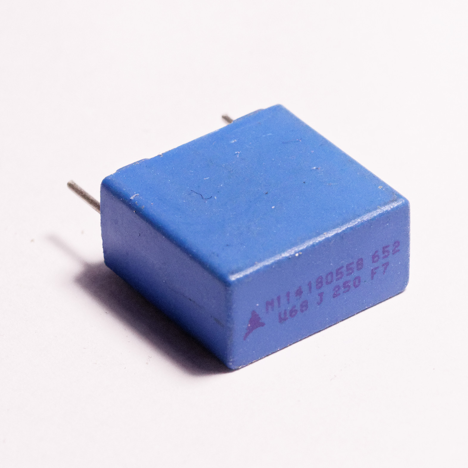 Figure 5 — Boxed metallized-polyester (MKT) capacitors, the small epoxy-cased general-purpose film parts found throughout analog electronics. Source: photograph by "Retired electrician," Wikimedia …