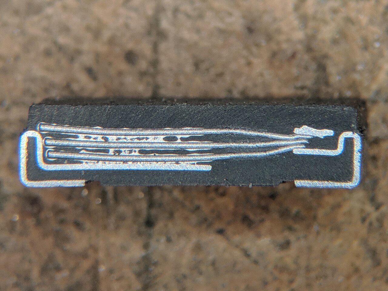 Figure 3 — Cross-section of a polymer tantalum capacitor: the tantalum sponge (light) with the conductive-polymer cathode (dark) worked into its pores, and the silver/graphite current collector at …