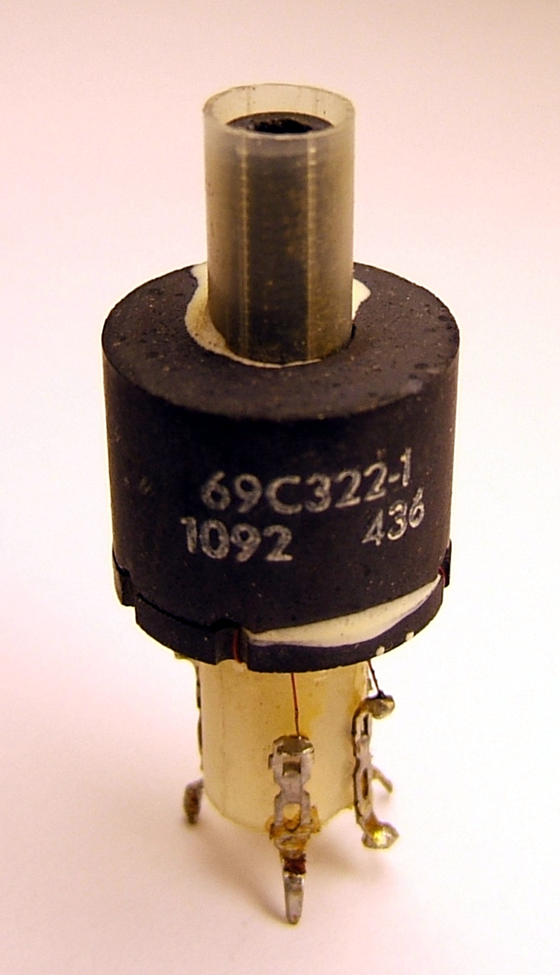 Figure 4 — A ferrite slug-tuned inductor built into a pot core; the threaded ferrite slug is adjusted with a non-metallic trimming tool to set the inductance. Source: photograph by Wikimedia Common…