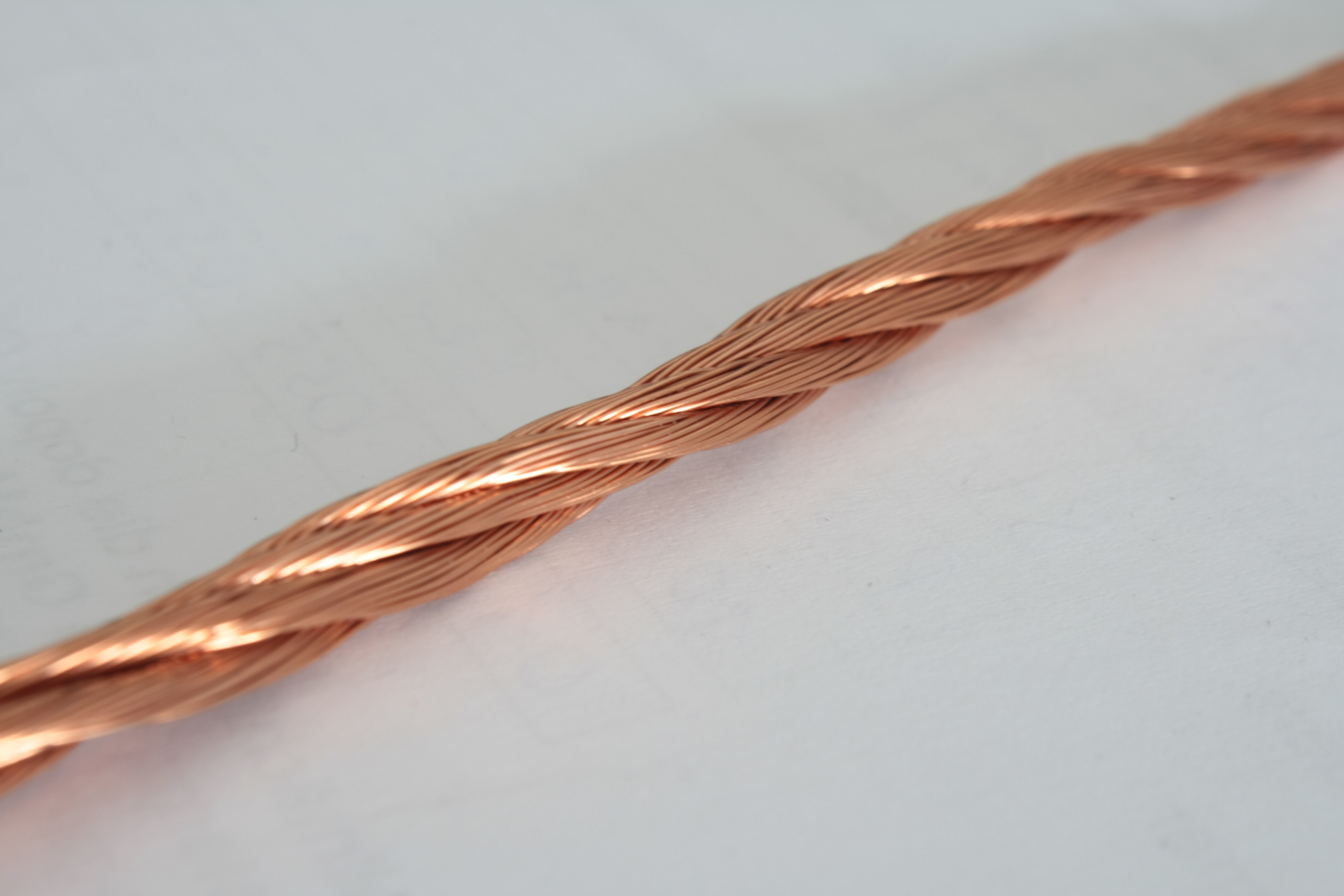 Figure 6 — Enamelled Litz wire close-up: the individually insulated fine strands that make it work are visible where the bundle is separated. Source: "Enamelled litz copper wire.JPG" by Alisdojo, W…