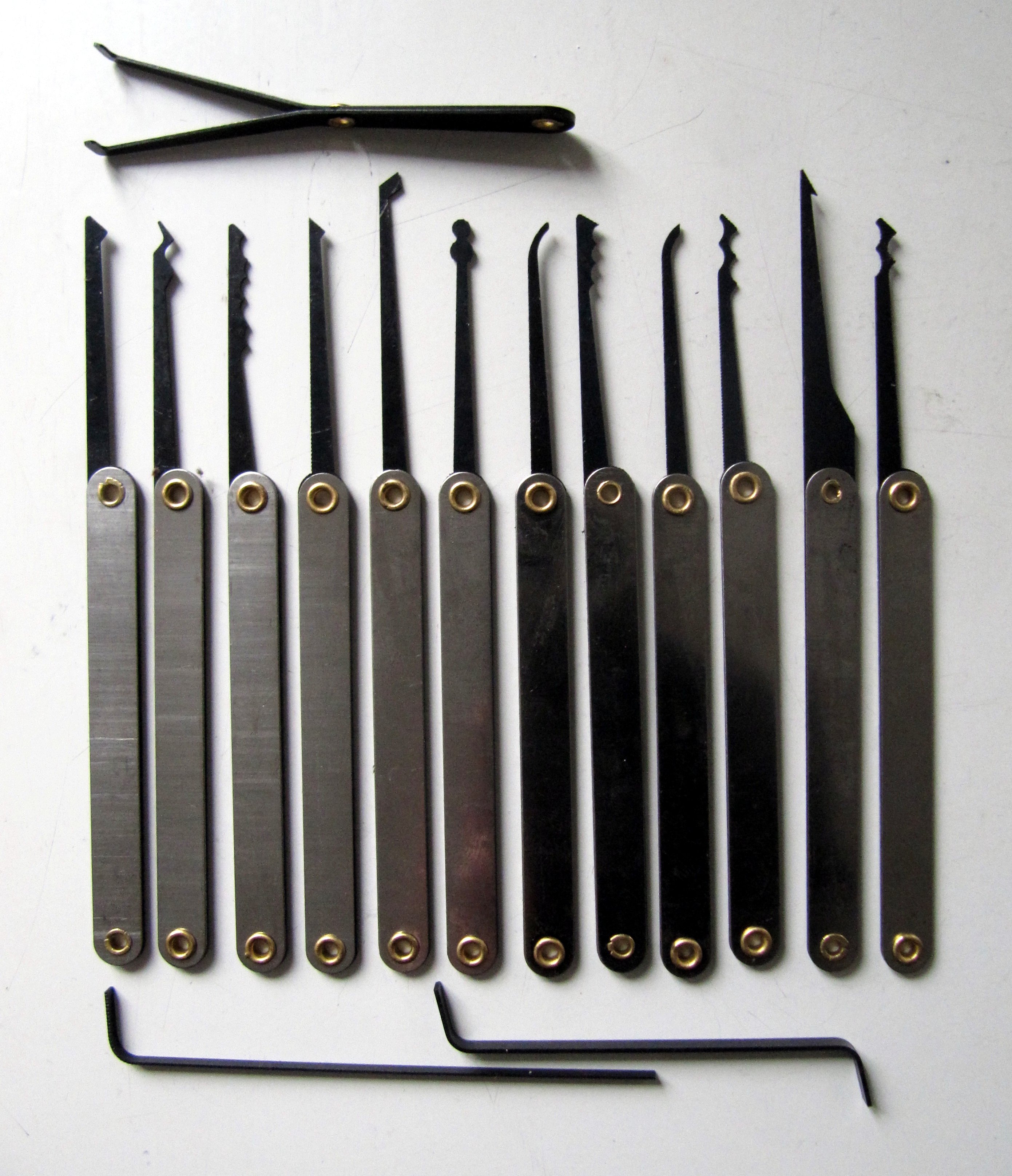 Figure 2 — A lock-picking set in working configuration — tension wrenches, single-pin picks, rake picks, and the broader physical-bypass toolkit that supports the red-team's physical-entry layer. Modern red-t…
