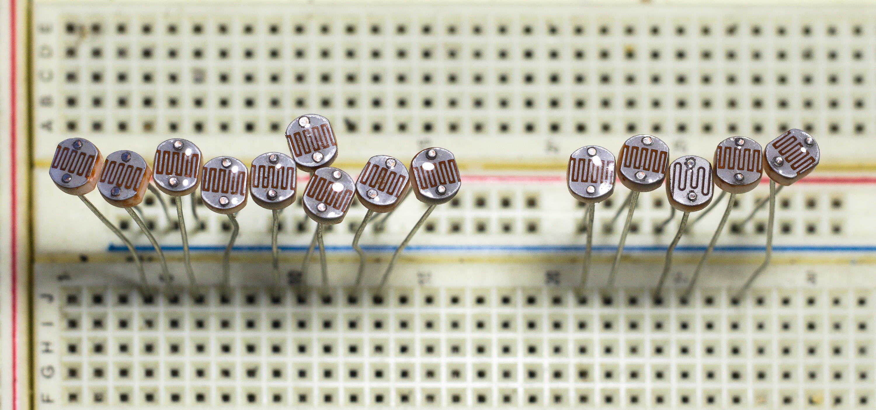 Figure 8 — Light-dependent resistors (LDRs / photoresistors): the classic GL5528 cadmium-sulphide cells, with the serpentine electrode over the photoconductive film clearly visible. Resistance fall…
