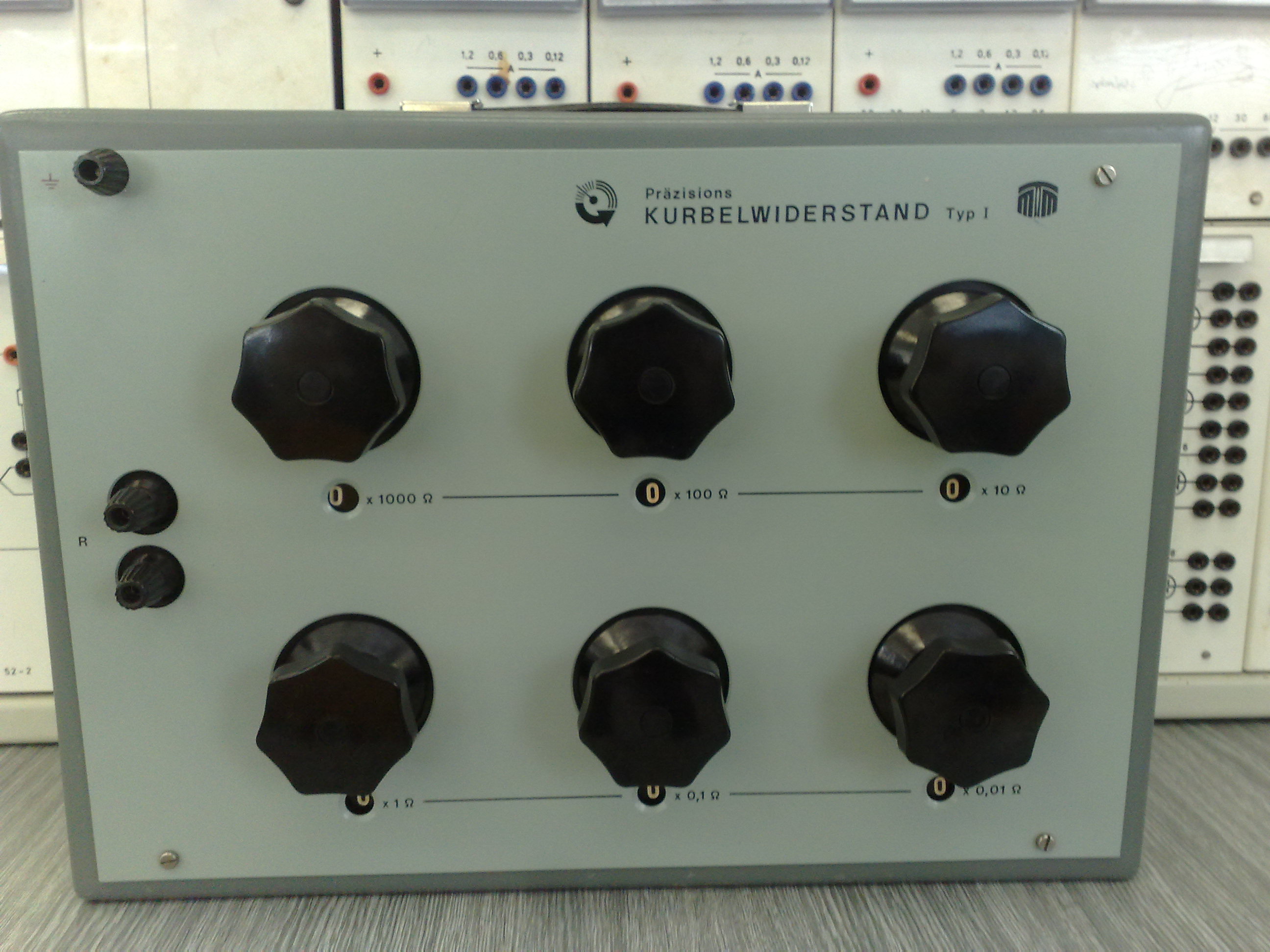 Figure 4 — A laboratory resistance decade box (this one an East German "Kurbelwiderstand"). Behind each dial sits a set of precision wirewound resistors — manganin wound on stable formers — switche…