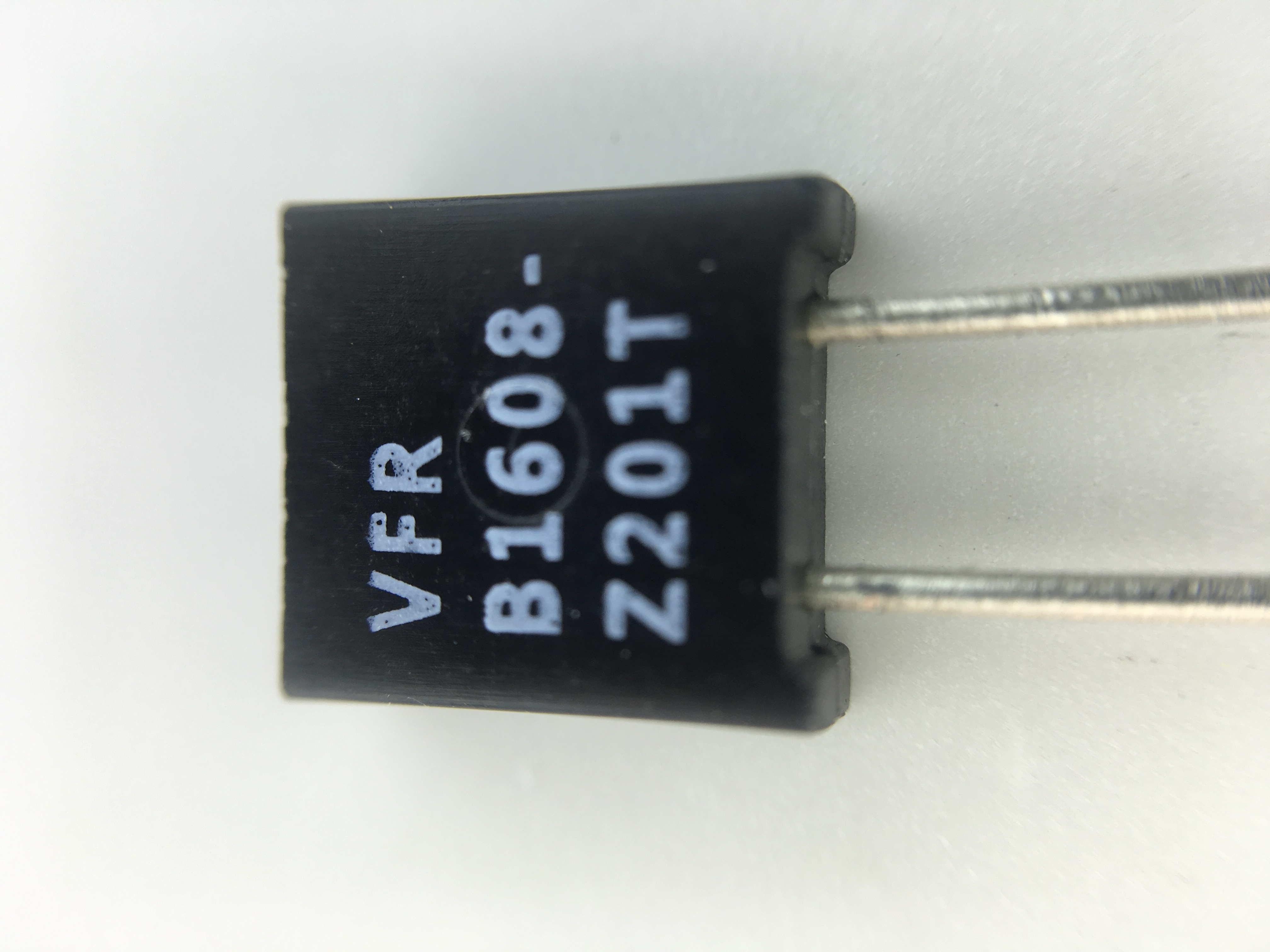 Figure 5 — A real bulk metal foil resistor: a Vishay Foil Resistors molded axial part (marked VFR, Z-Foil, in a B1608-size body). Inside the black molding is the photo-etched Ni-Cr foil bonded to i…