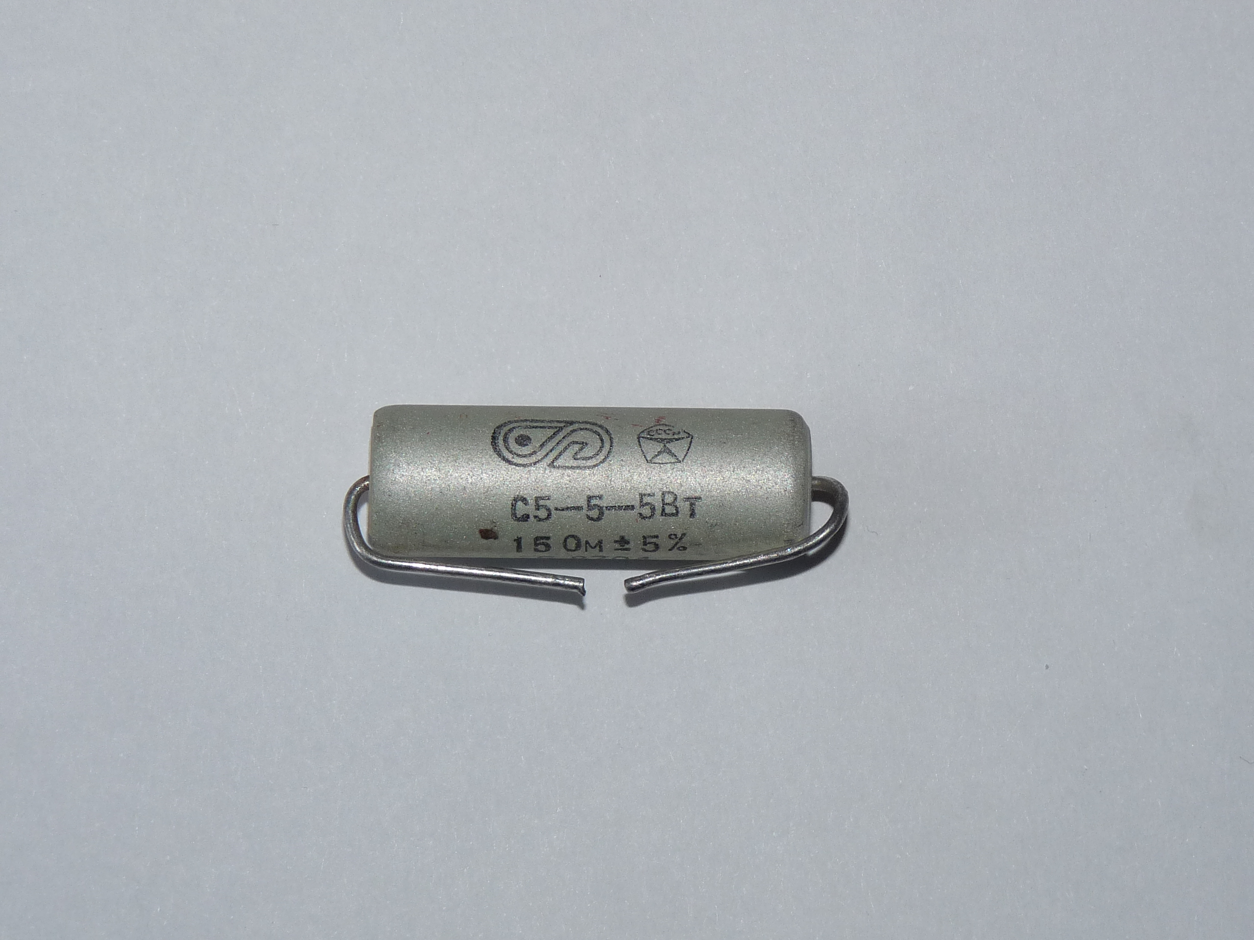 Figure 7 — A vitreous-enamel wirewound power resistor (Soviet С5-5, 15 Ω ±5%, 5 W). Resistance wire is wound on a ceramic tube and sealed under a vitrified glass coating that protects the winding a…