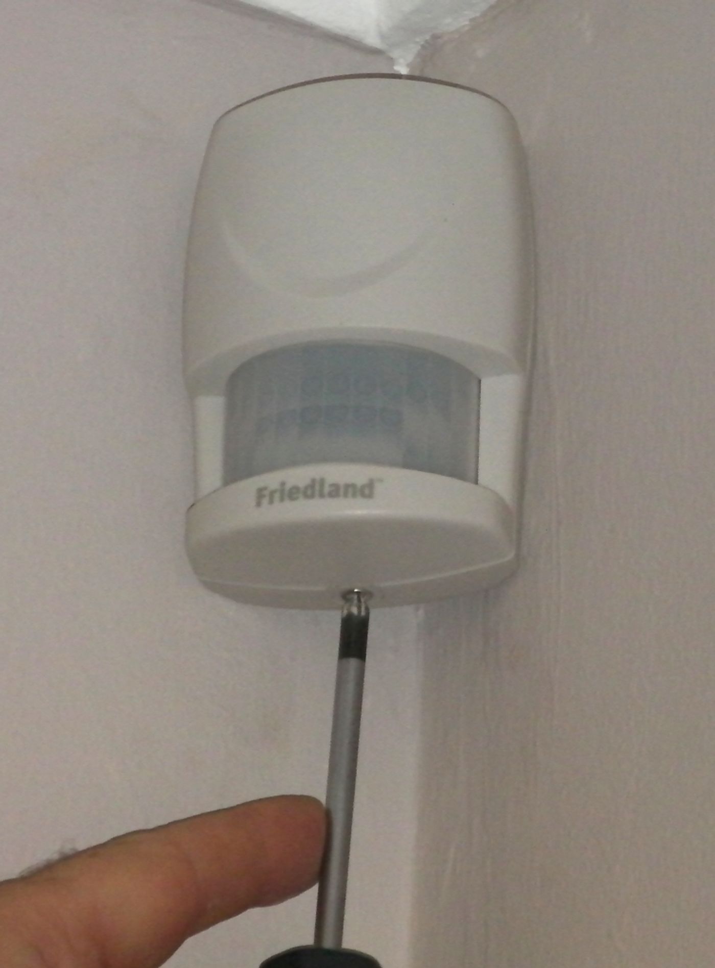Figure 4 — A corner-mounted passive-infrared (PIR) motion detector, the interior workhorse of a SCIF intrusion-detection system. It senses the moving thermal signature of a person crossing its fan …