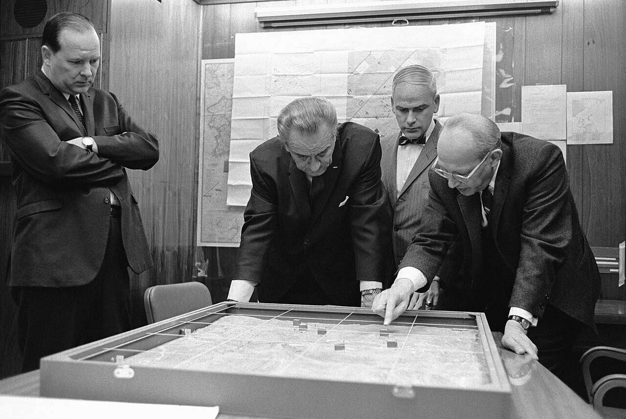 Figure 2 — Walt Rostow briefs President Lyndon B. Johnson using a terrain model of Khe Sanh in the White House Situation Room, 1968. The Situation Room's function as a protected space for handling …