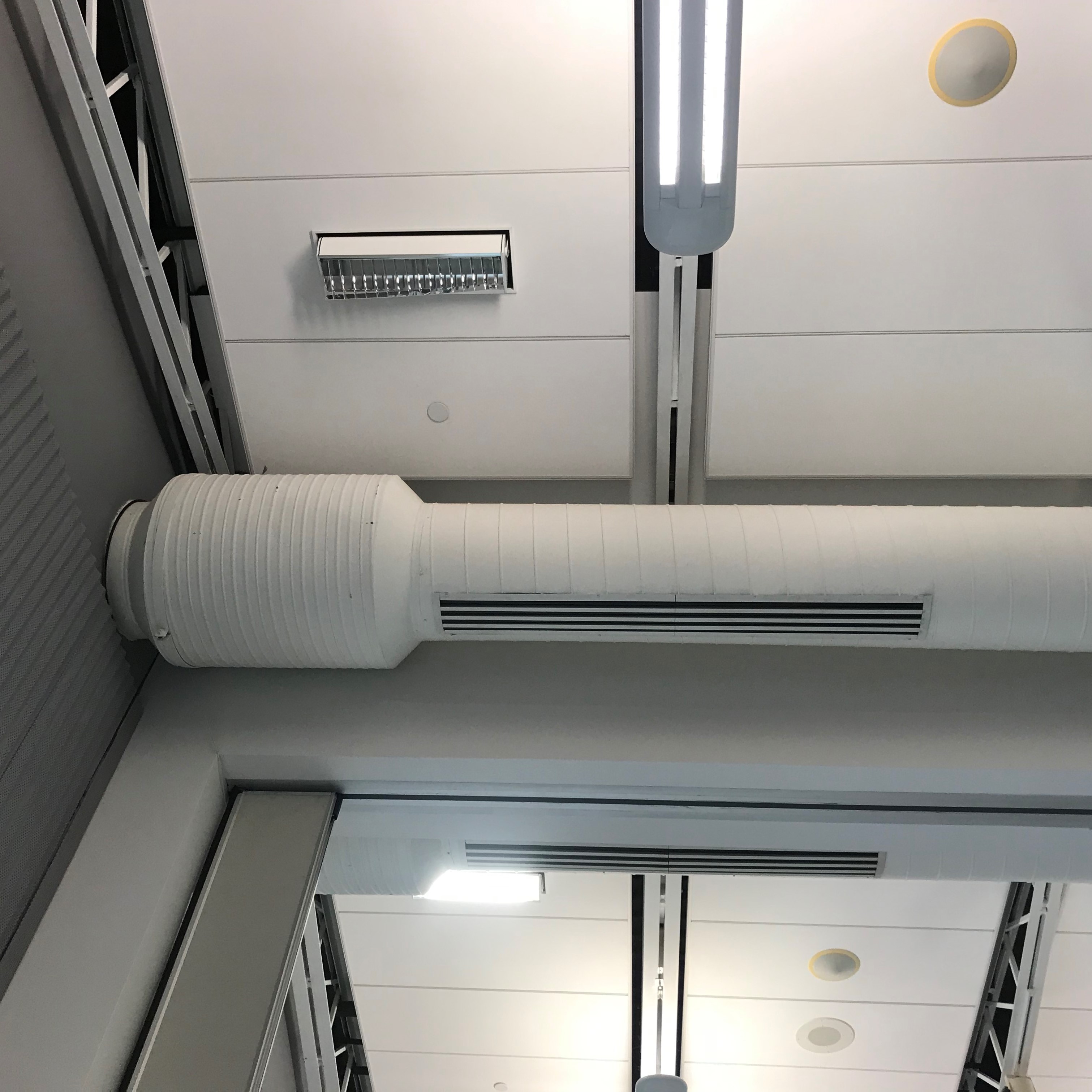 Figure 5 — Figure E — A circular duct sound trap (attenuator) installed in HVAC ductwork; the trap's outer diameter is larger than the surrounding duct because it packs absorptive baffle material around and t…