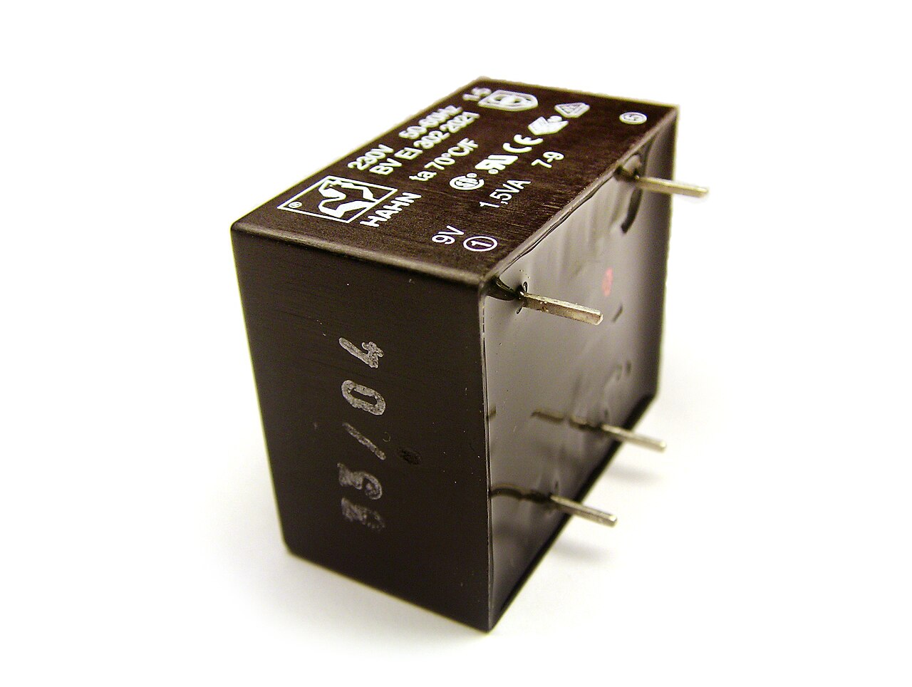 Figure 7 — A small transformer fully potted in resin: the winding has been impregnated and encapsulated, locking every turn, sealing out moisture, and conducting the coil's heat out to the block's …