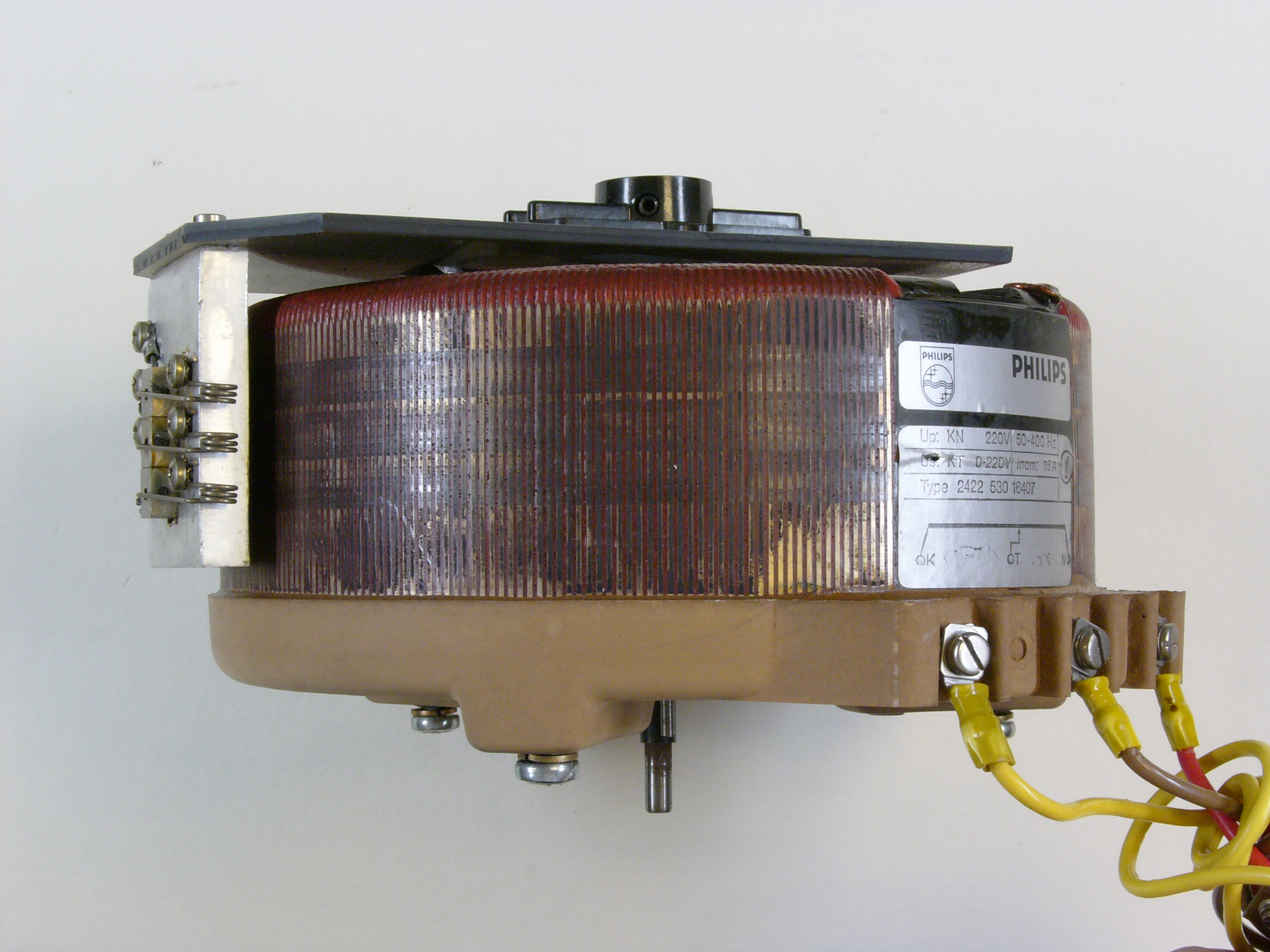 Figure 5 — A toroidal mains transformer: grain-oriented steel ribbon wound into a closed ring, with the primary and secondary wound over it through the hole. Source: photograph by Hannes Grobe/AWI,…